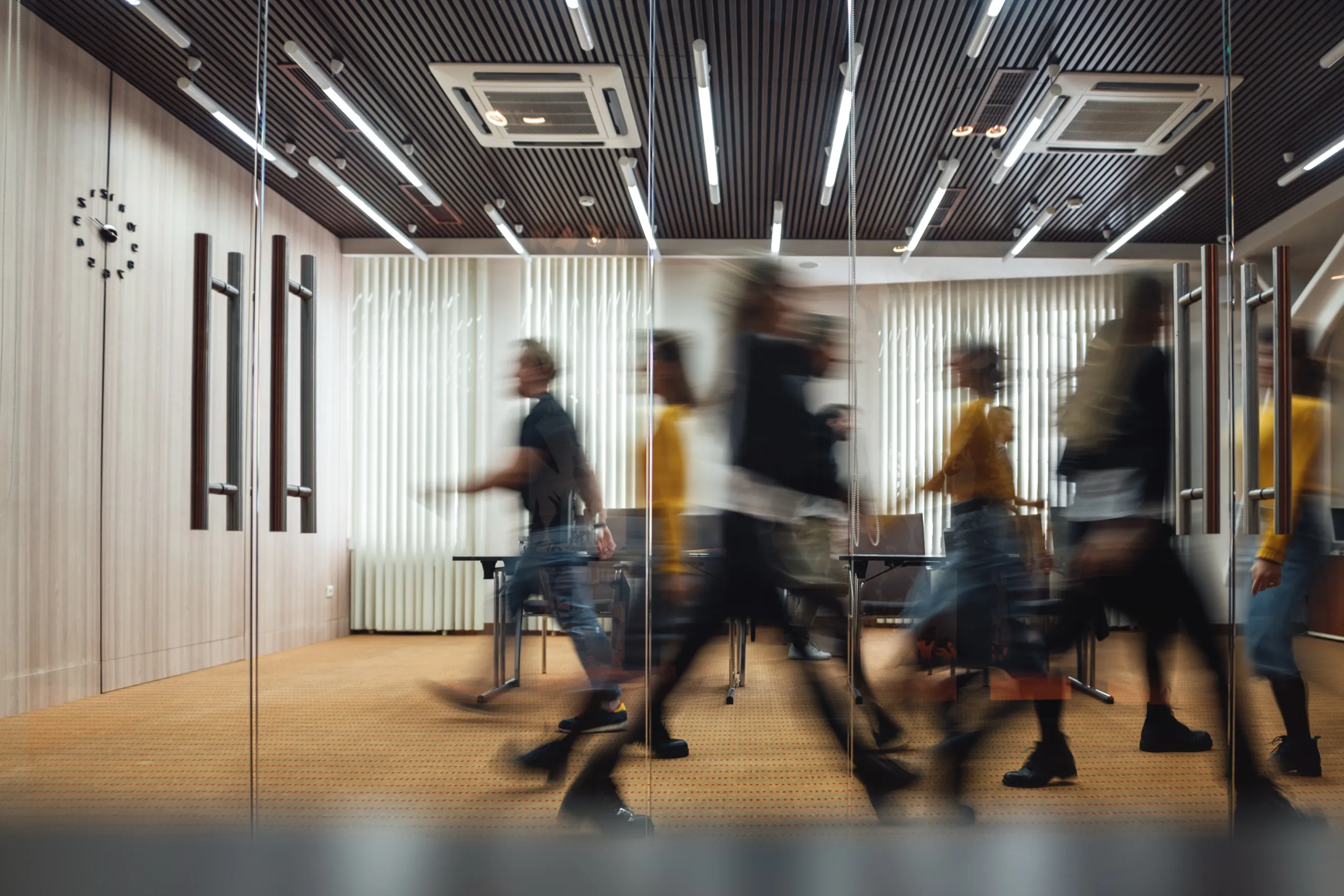 Personnes en mouvement dans une salle de réunion vitrée