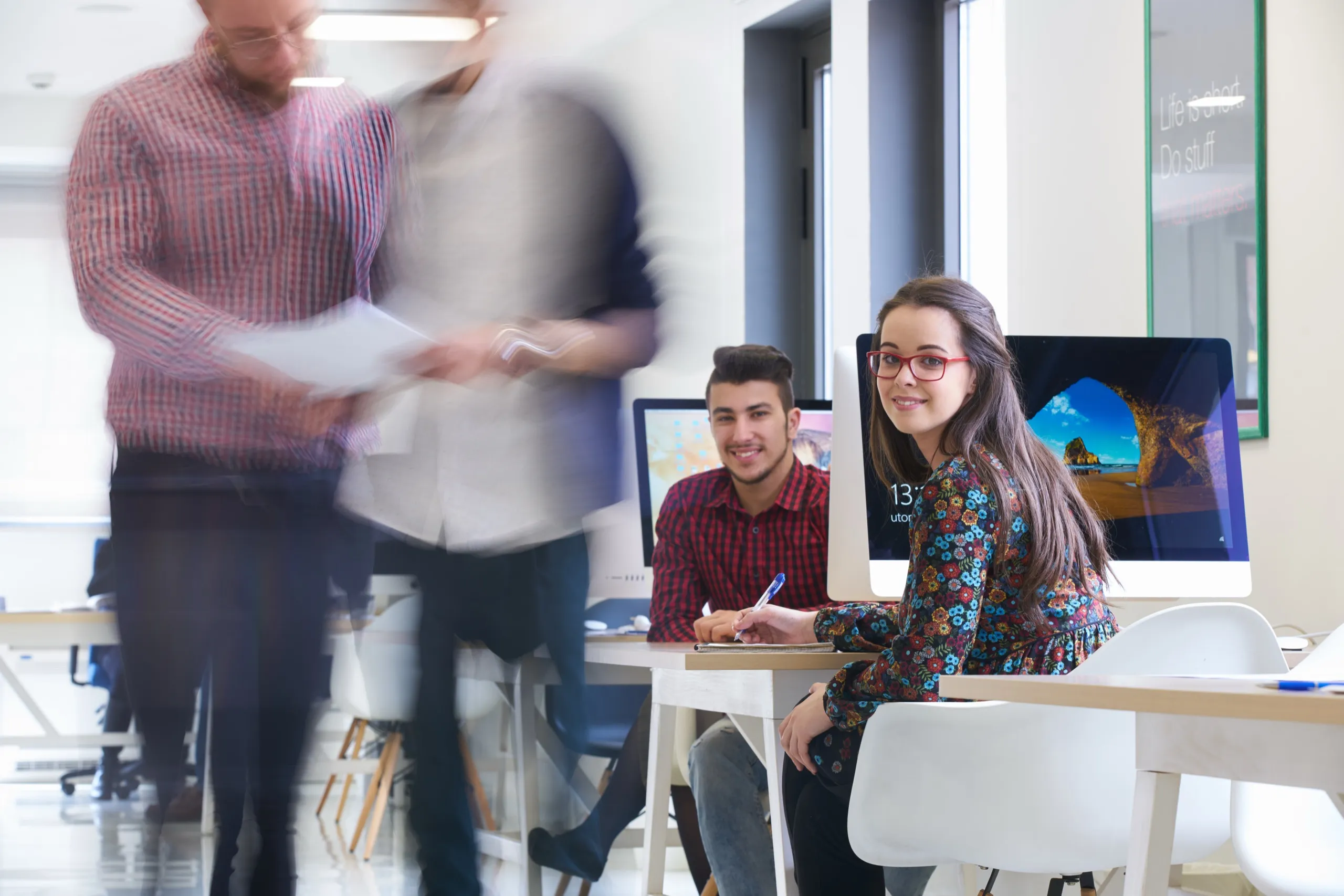 Jeunes professionnels souriants à leur poste de travail