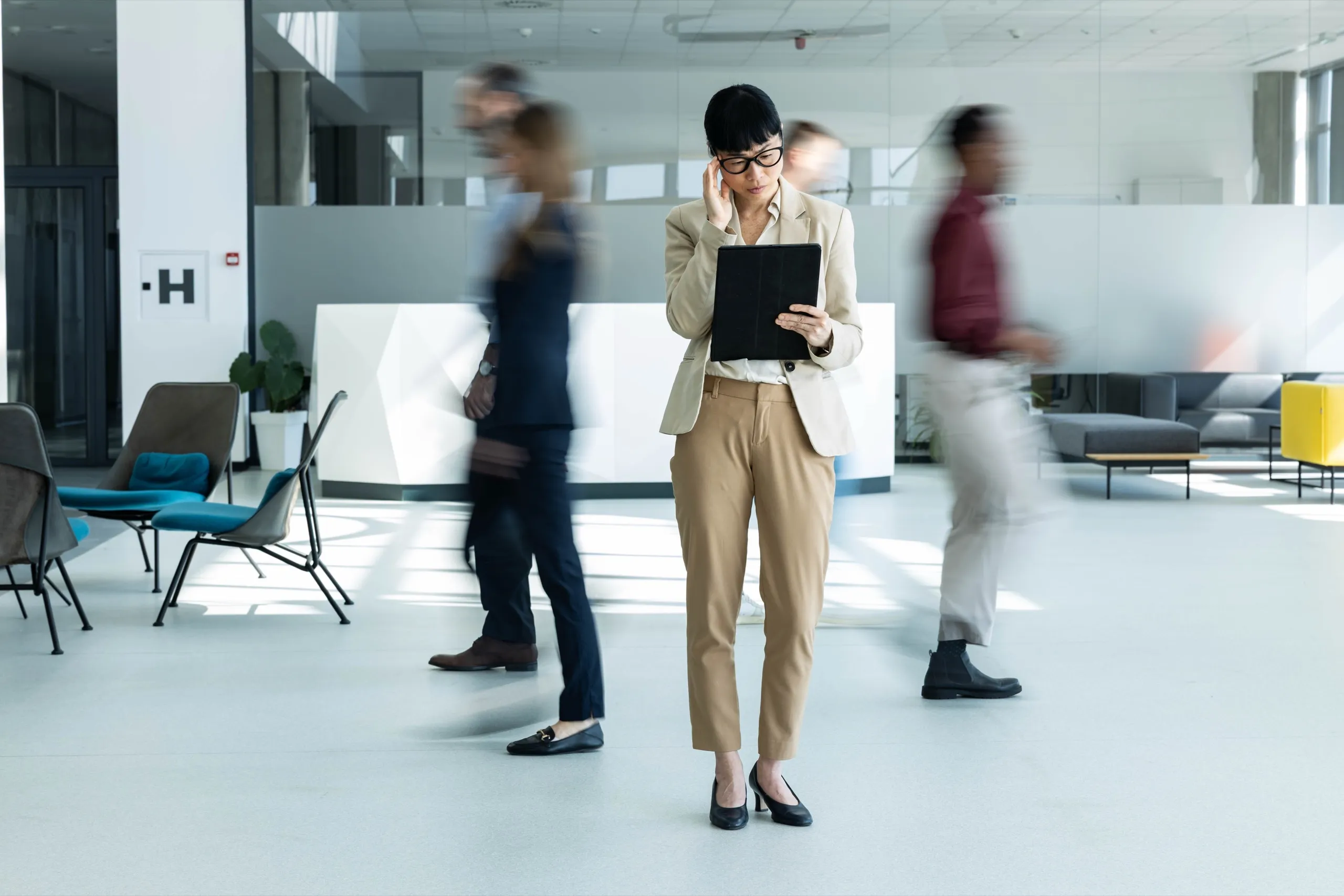 Femme consultant une tablette dans un hall achalandé
